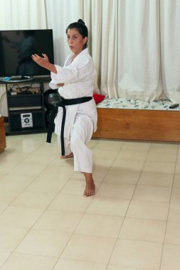 Latin Kadın evde karate eğitimi veriyor.