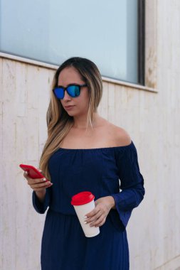 İspanyol kadın, genç ve güzel, dışarıda tek başına duruyor, cep telefonu kullanıyor..