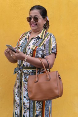 Açık hava video konferansında cep telefonu kullanan olgun İspanyol kadın.