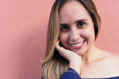 Eli çenesinde kameraya bakan mutlu bir kadın.