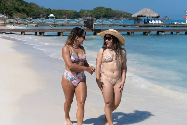 Gelinler kumsalda yürüyor ve yaz tatillerinin tadını çıkarıyor.