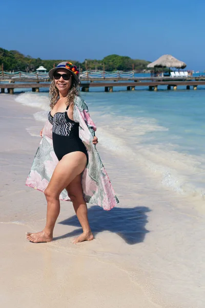 Kadın sahilde tatilin tadını çıkarıyor.