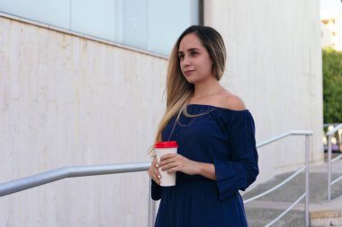 Kahveli Latin iş kadını, arka planda ofis binası.