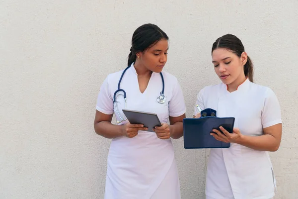 Zwei Krankenschwestern Betrachten Das Klemmbrett Während Sie Krankenhaus Arbeiten — Stockfoto