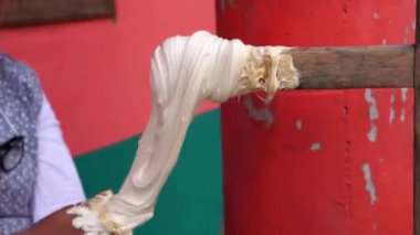 Kadının elleri sokakta şeker hazırlıyor.