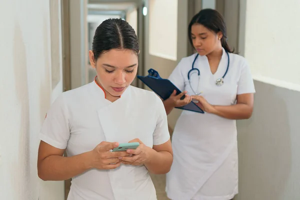 Paar Von Sanitätern Blickt Auf Einen Handybildschirm — Stockfoto