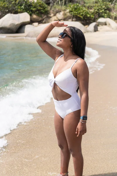 Plajda güneş ışığını engellemek için yüzünü örten Afrikalı kadın.