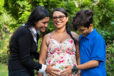 Oğullar annelerinin ellerini karnında tutarlar.