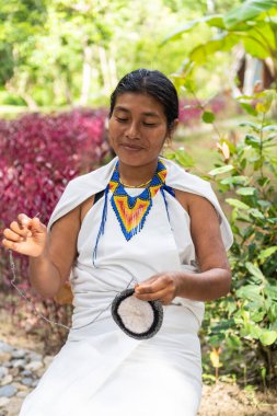 Sierra Nevada 'dan yerli bir kadın Santa Marta' da oturuyor ve örgü örüyor.