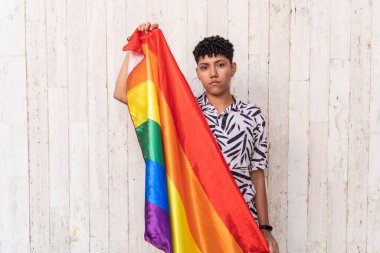 Güzel genç LGBT + kadın sokakta gökkuşağı bayrağıyla poz veriyor