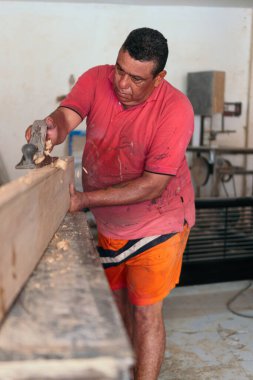 Latin Man places finishing details on piece of furniture