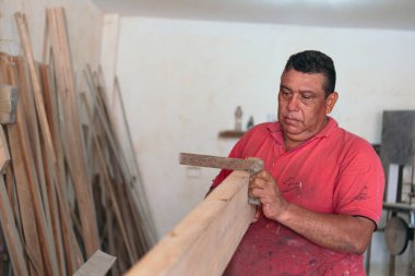 Owner of carpentry workshop working with wood