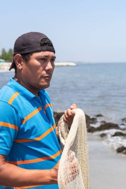 Kıyıdaki okyanusta Latin balıkçı