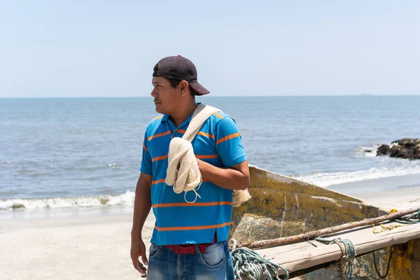 Fisherman looking away while carrying a fishing net