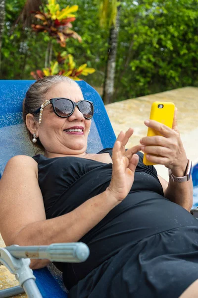 Hispanic Woman Sitting Poolside Checking Smartphone — Φωτογραφία Αρχείου