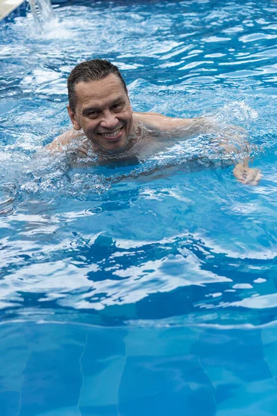 Mature Man Relaxes His Pool — Photo