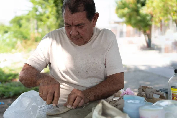 Shoemaker repairs shoes in the street