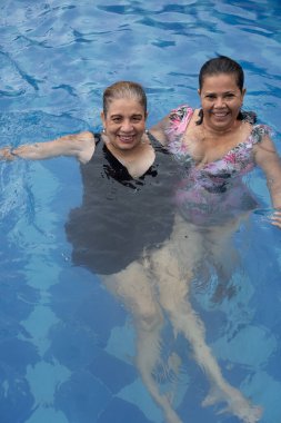 Mature women relaxing by the pool in the sunshine