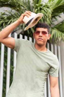 A man takes off his hat in the open air