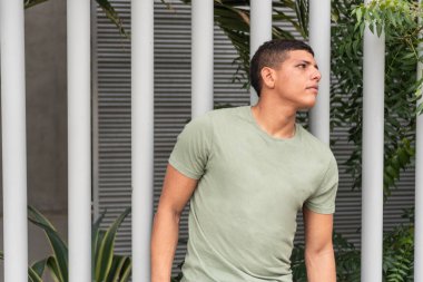 Latin man looking to the side, on city street.