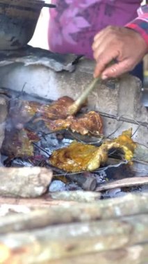 Hands of a man roasting a meat in the field