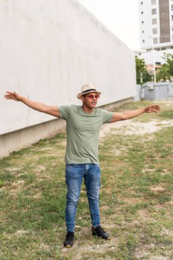 man with arms outstretched in park