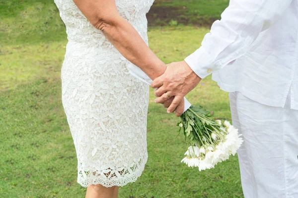 married couple holding bouquet of flowers