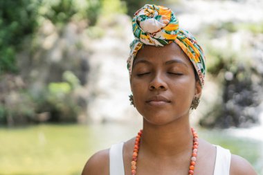 Kameranın önünde poz veren gözleri kapalı genç bir kadın..