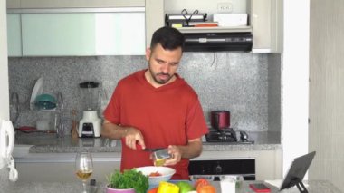 Sakallı adam sağlıklı sebze ve meyve salatası pişiriyor..