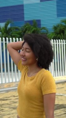 Parkta müzik dinleyen Afro bir kadın.
