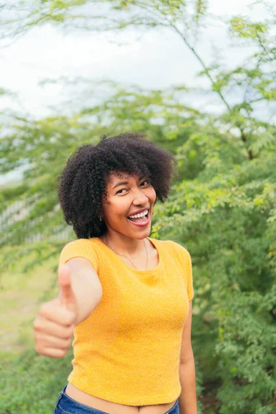 Afro Donna Guardando Fotocamera Mentre Posa Uno Sfondo Verde Naturale — Foto Stock