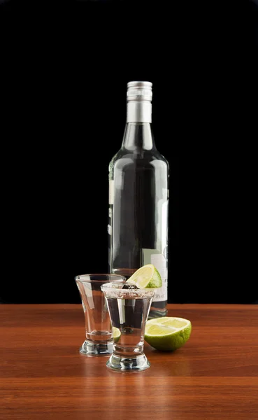 Dos vasos de tequila, botella, sal y lima — Foto de Stock