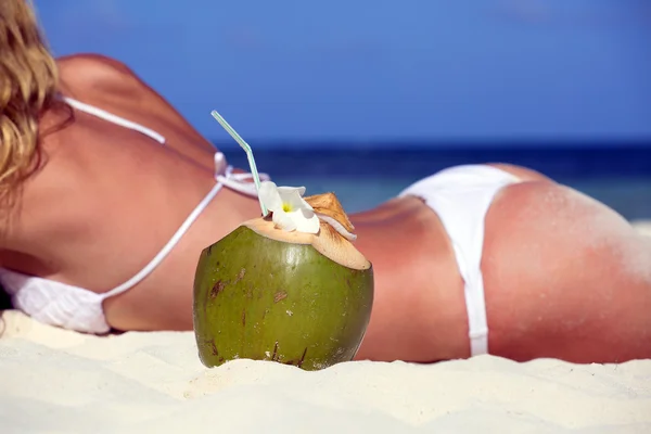 Noix de coco sur le fond des filles sur la plage — Photo