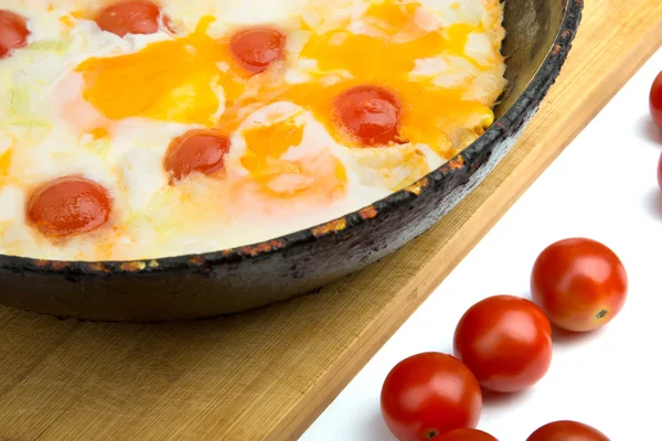 Ovos com tomates de cereja em uma panela — Fotografia de Stock