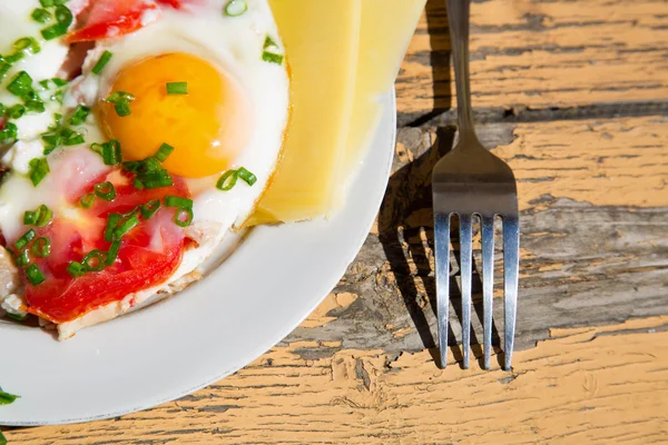 Ovos, cebolas verdes e tomates na velha mesa de madeira — Fotografia de Stock