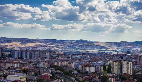 Yigitler, Sivas, Türkiye-Eylül-Pazartesi-2021: Bulutlu bir gün ve şehir manzarası. Güneş ışınları bulutları delip geçiyor. Daireler. Sivas şehir merkezi üst görünümü
