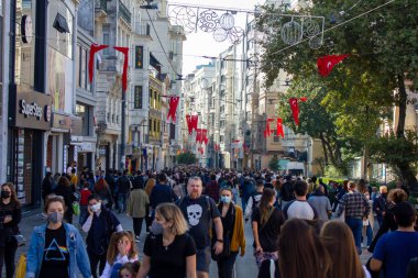 Taksim, İstanbul, Türkiye-Ekim-Cumartesi-2021: Ünlü istiklal Caddesi 'nde yürüyen insanlar. Alışveriş merkezleri, tarihi binalar ve tren rayları