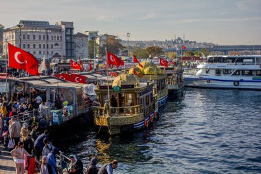 Eminonu, İstanbul, Türkiye-Ekim-Cumartesi-2021: Bulutlu hava, yürüyen insanlar. Balık ve ekmek buharı ve Boğaz manzarası.