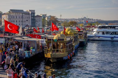 Eminonu, İstanbul, Türkiye-Ekim-Cumartesi-2021: Bulutlu hava, yürüyen insanlar. Balık ve ekmek buharı ve Boğaz manzarası.
