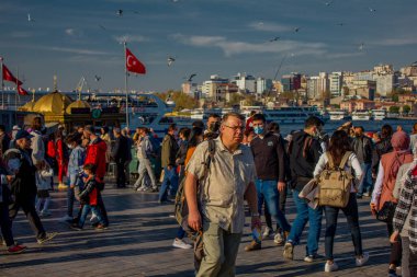 Eminonu, İstanbul, Türkiye-Ekim-Cumartesi-2021: Bulutlu hava, yürüyen insanlar. Balık ve ekmek buharı ve Boğaz manzarası.