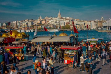 Eminonu, İstanbul, Türkiye-Ekim-Cumartesi-2021: Bulutlu hava, yürüyen insanlar. Balık ve ekmek buharı ve Boğaz manzarası.