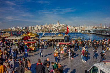 Eminonu, İstanbul, Türkiye-Ekim-Cumartesi-2021: Bulutlu hava, yürüyen insanlar. Balık ve ekmek buharı ve Boğaz manzarası.