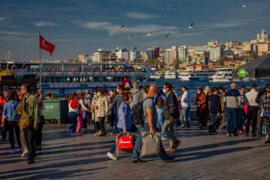 Eminonu, İstanbul, Türkiye-Ekim-Cumartesi-2021: Bulutlu hava, yürüyen insanlar. Balık ve ekmek buharı ve Boğaz manzarası.
