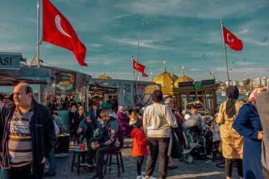 Eminonu, İstanbul, Türkiye-Ekim-Cumartesi-2021: Bulutlu hava, yürüyen insanlar. Balık ve ekmek buharı ve Boğaz manzarası.