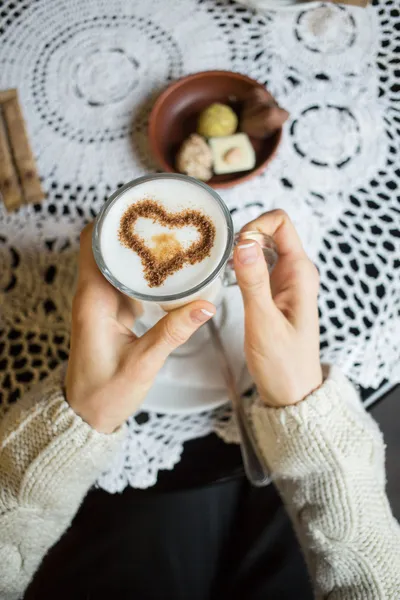Mulher segurando xícara quente de café com forma de coração — Fotografia de Stock