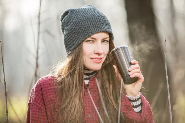 Junge Frau hält Becher mit Heißgetränk im Freien — Stockfoto