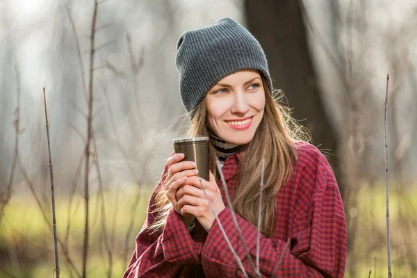 Mladá žena hospodářství kávu venku — Stock fotografie
