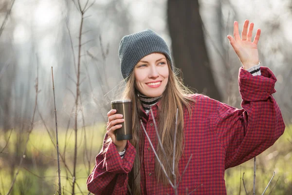 Mladá žena držící šálek horké nápoje venkovní — Stock fotografie