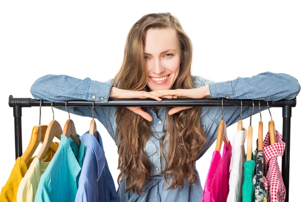 Beautiful young woman near rack with hangers — Stock Photo, Image