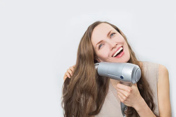 Щаслива жінка висушує волосся — стокове фото